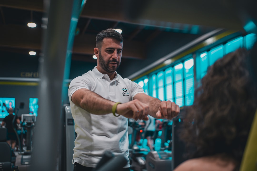 A man in a white shirt and black pants in a gym