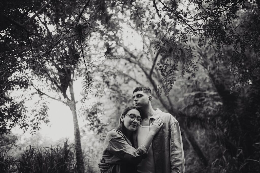 a man and a woman standing in the woods