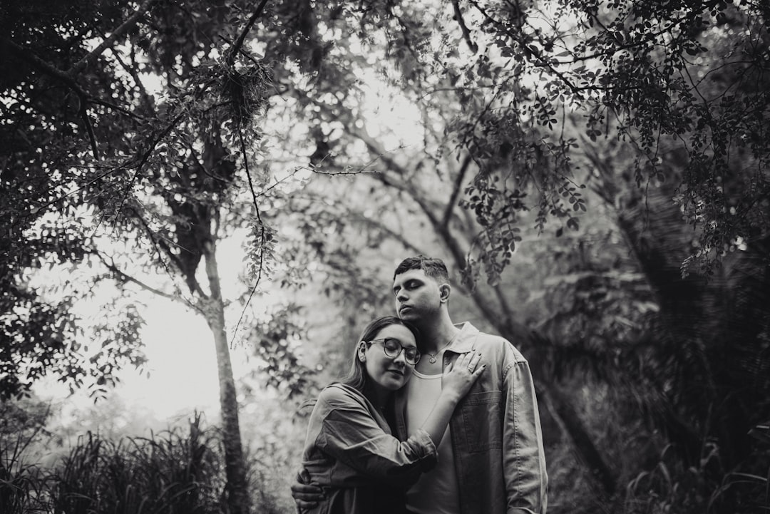a man and a woman standing in the woods