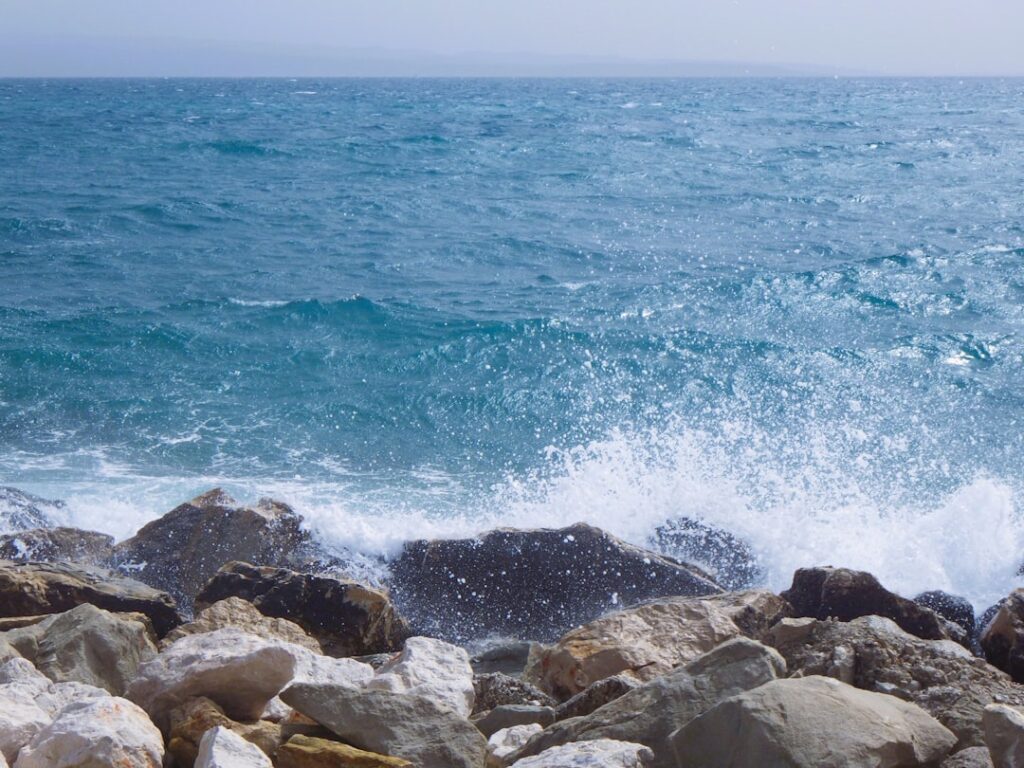 a large body of water sitting next to a rocky shore